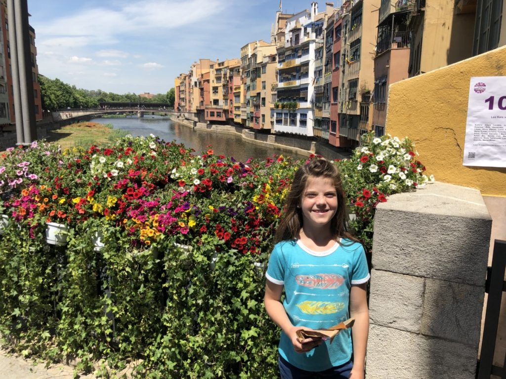 Young Girlon a flower bridge in Girona, Spain