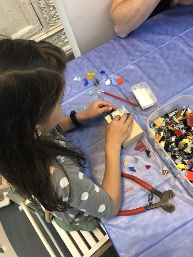 Young Girl creating a tile Mosaic on top of jewelry box at Mosaicos, Barcelona