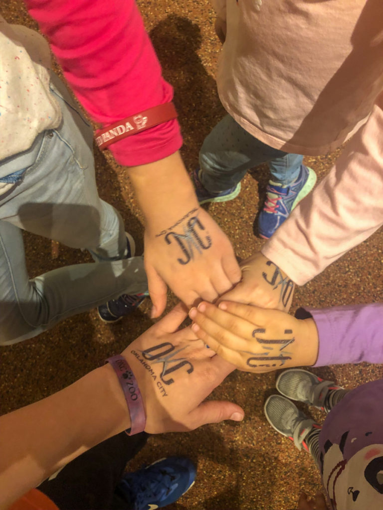 4 kids hands with OKC oklahoma City Tattoos