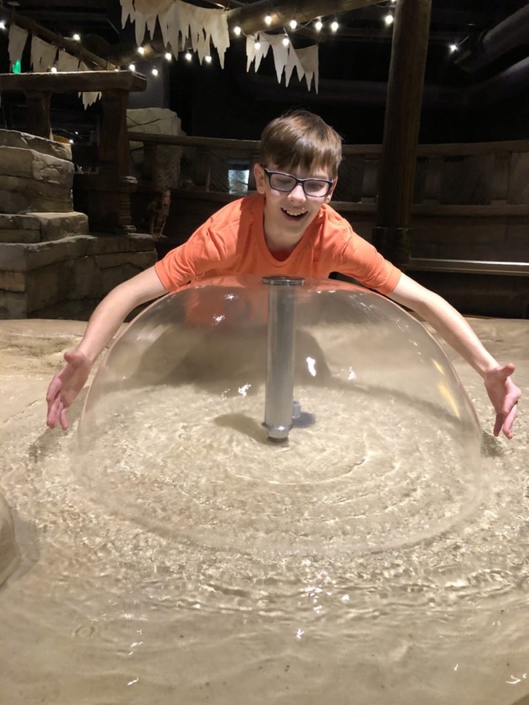 aboy tries to hug a water bubble at the Science Museum of OKlahoma in OKC with kids