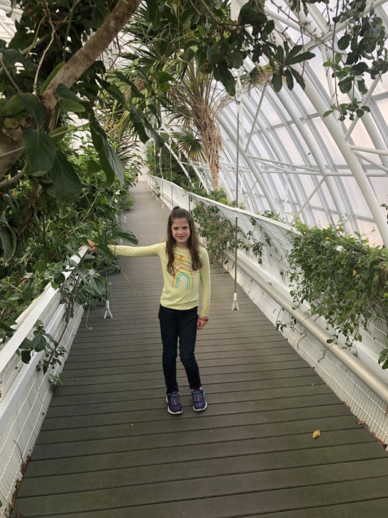 A girl smiles on Crystal Bridge in Myriad Botanical Garden in OKC