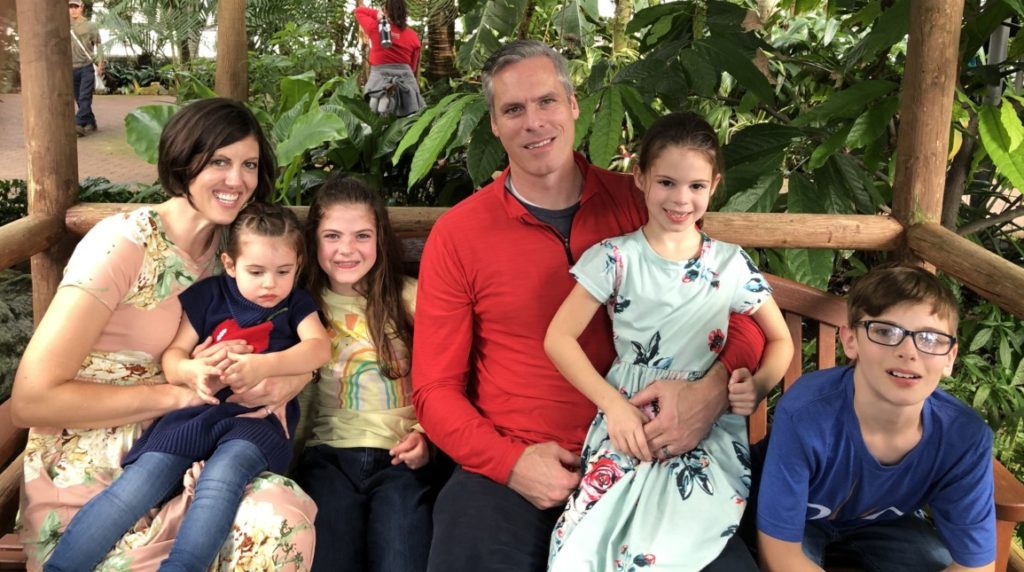 Family of 6 sitting in myriad Botanical Garden Crystal Bridge 