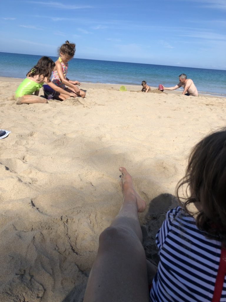 4 kids with dad Playing in the Sand at Hapuna beach State park