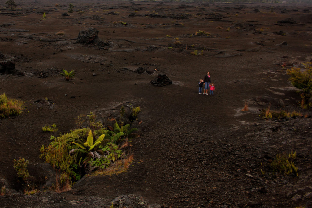 Mom and 3 kids stand in a Lava Field