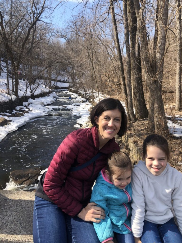 Mom and 2 girls at Minnehah state Park looking over a snow-lined stream