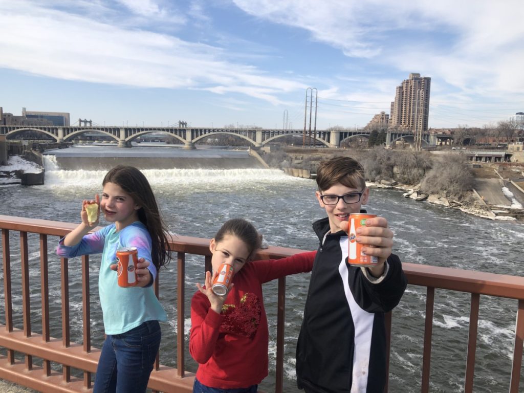 3 kids Drinking Mini-sodas in Minnesota at St. Anthony Falls downtown Minneapolis