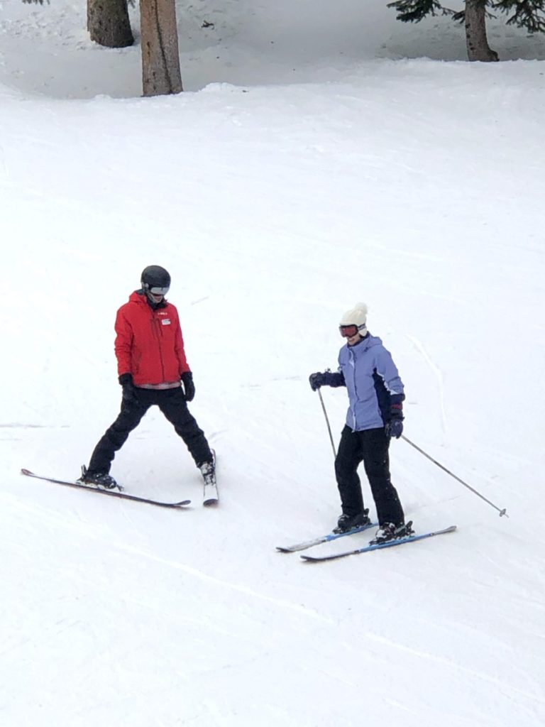 Woman learns to turn with ski school instructor at Brighton Ski Resort
