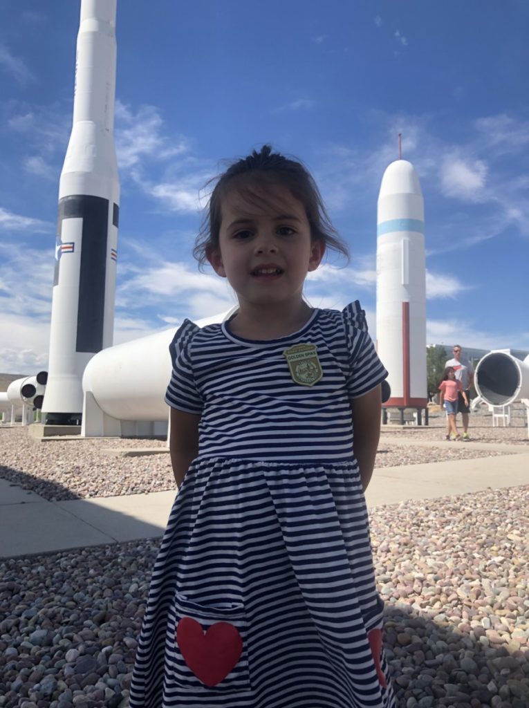 Toddler between 2 rockets at ATK rockets, Utah