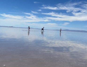 Dad and 2 daughters skipping rocks in the Great Salt Lake