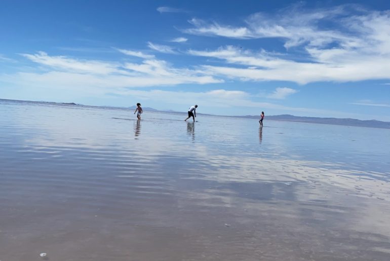 Dad and 2 daughters skipping rocks in the Great Salt Lake