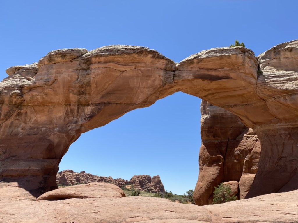 woman stands at broken arch