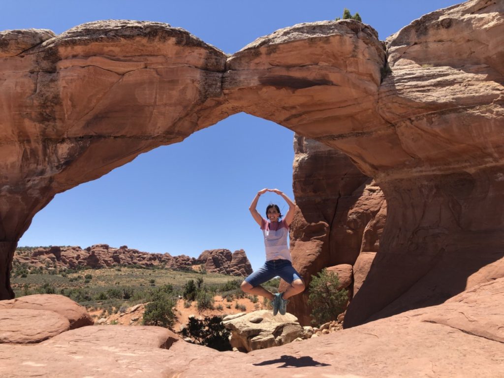 Mom does a pirouette Jump under Broken Arch in Sand Dune Arch