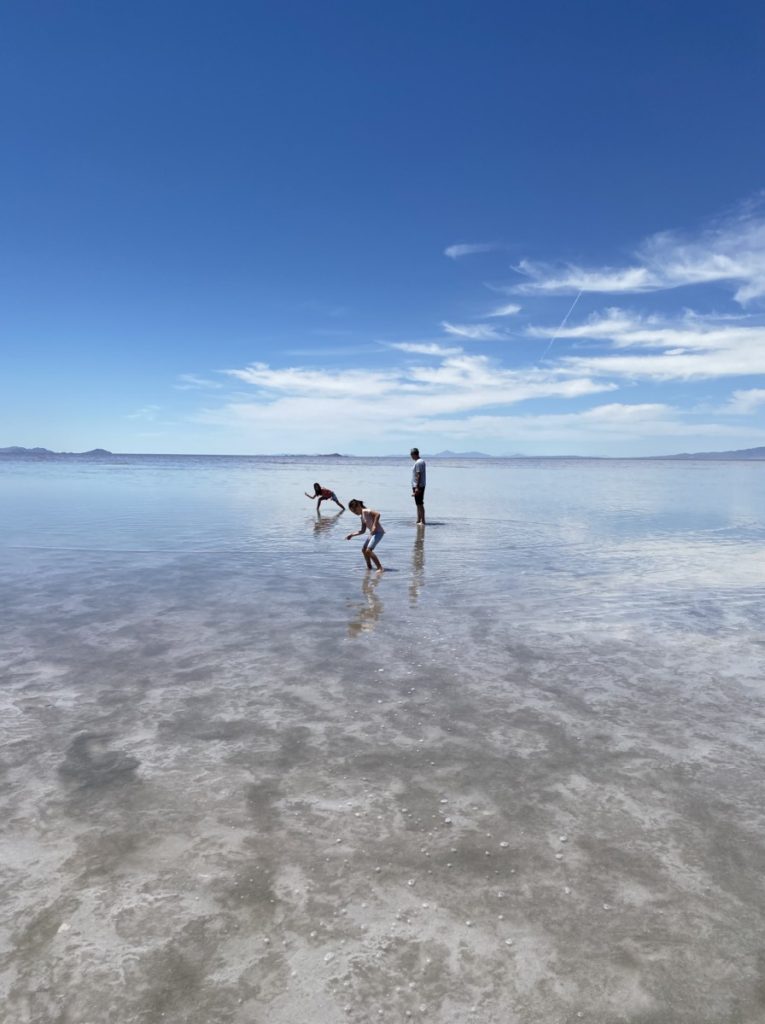 dad and 2 daughters skipping rocks at the Great Salt Lake