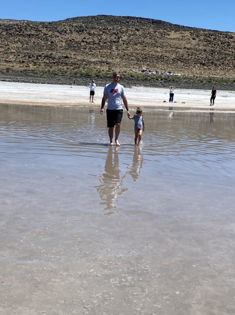 Dad and Daughter holding hands walking in the shallow Great Salt Lake