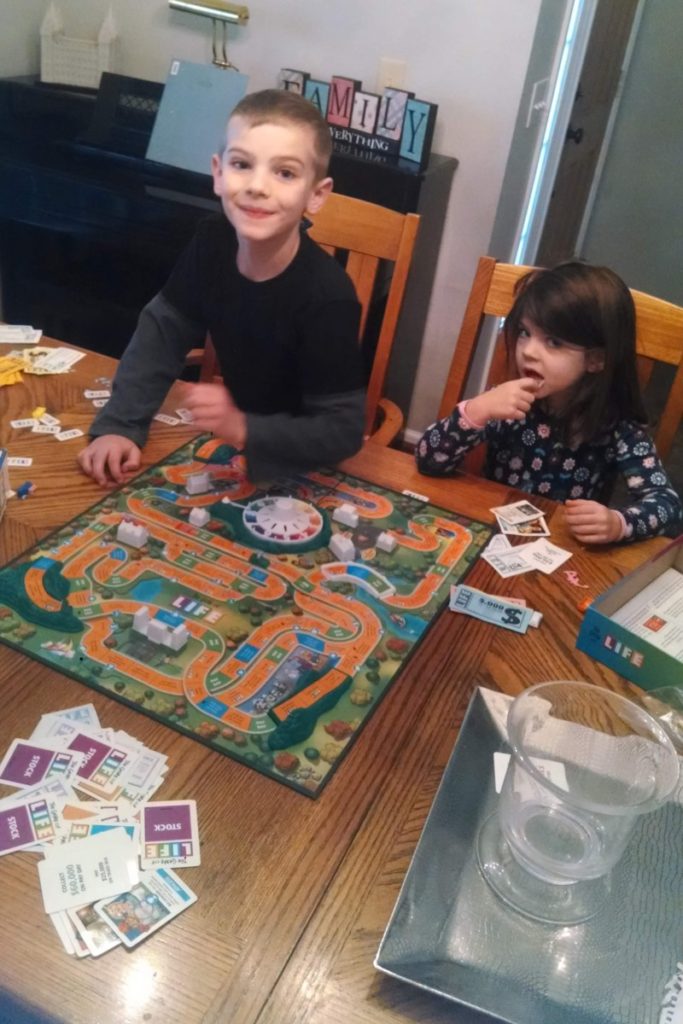 2 kids playing the game of life 