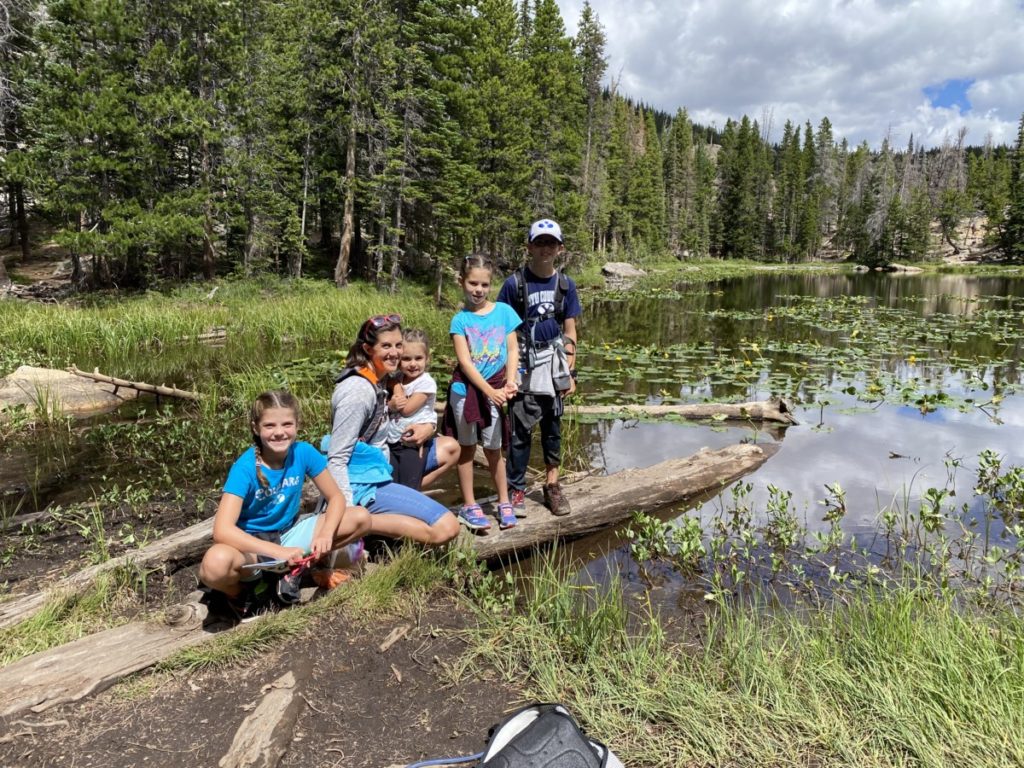 Mom and 4 kids standing on a sunken log at Nymph Lake