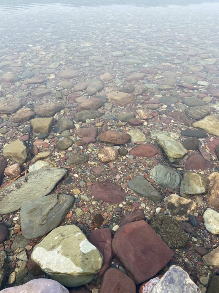 Clear water with colorful rocks at McDonalds Lake in Glacier National Park