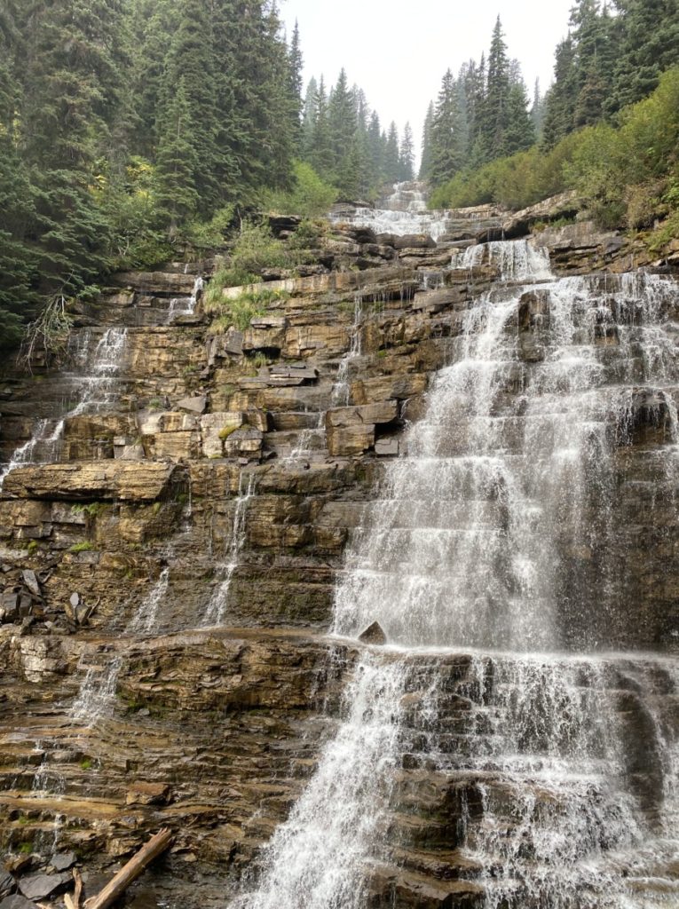 Water cascades down square rock levels at Florence Falls in Glacier National Park
