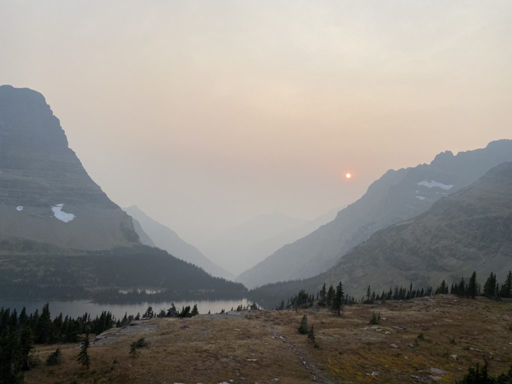 Sunset behind a smoky, hazy sky at HIdden Lake in Glacier National Park