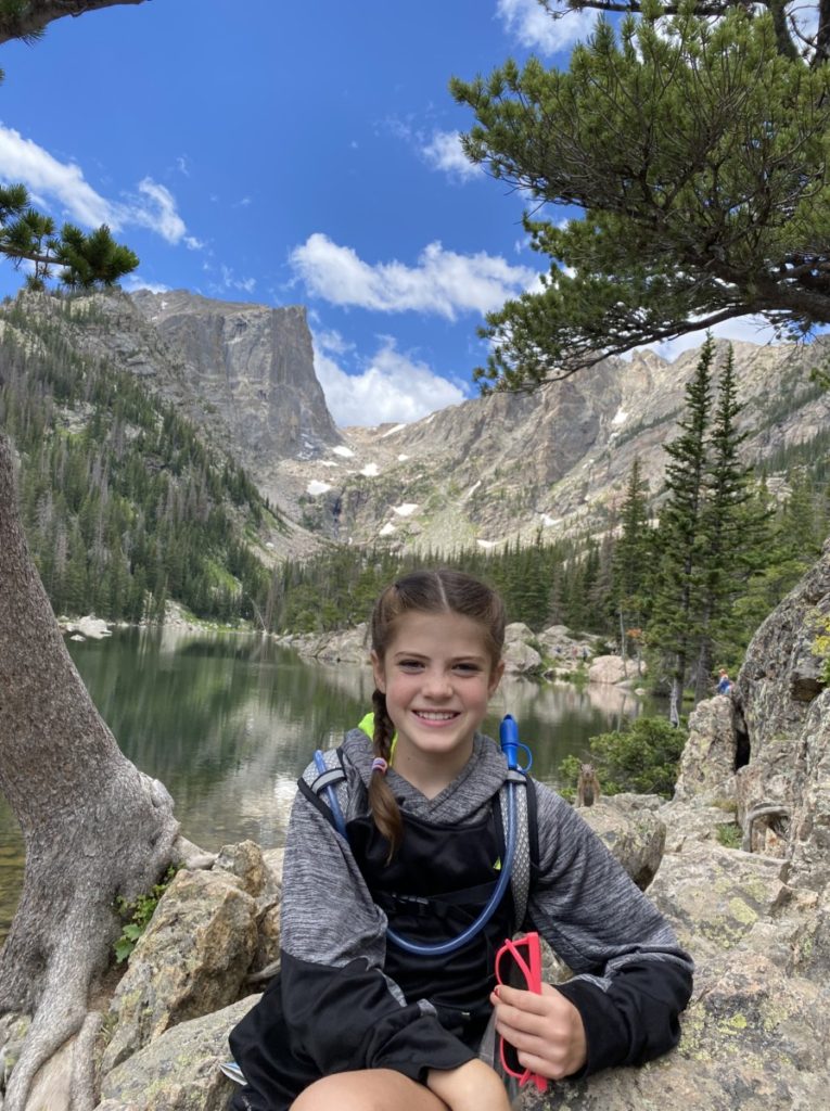 A young girl in front of Dream Lake surrounded by Boulders in Rocky Mountain National Park