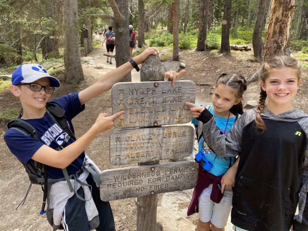 3 Kids pointing to Emerald Lake trail head sign