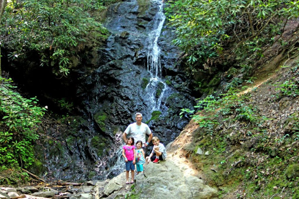 Dad and 3 kids hiking at a waterfall in Smoky Mountain National Park