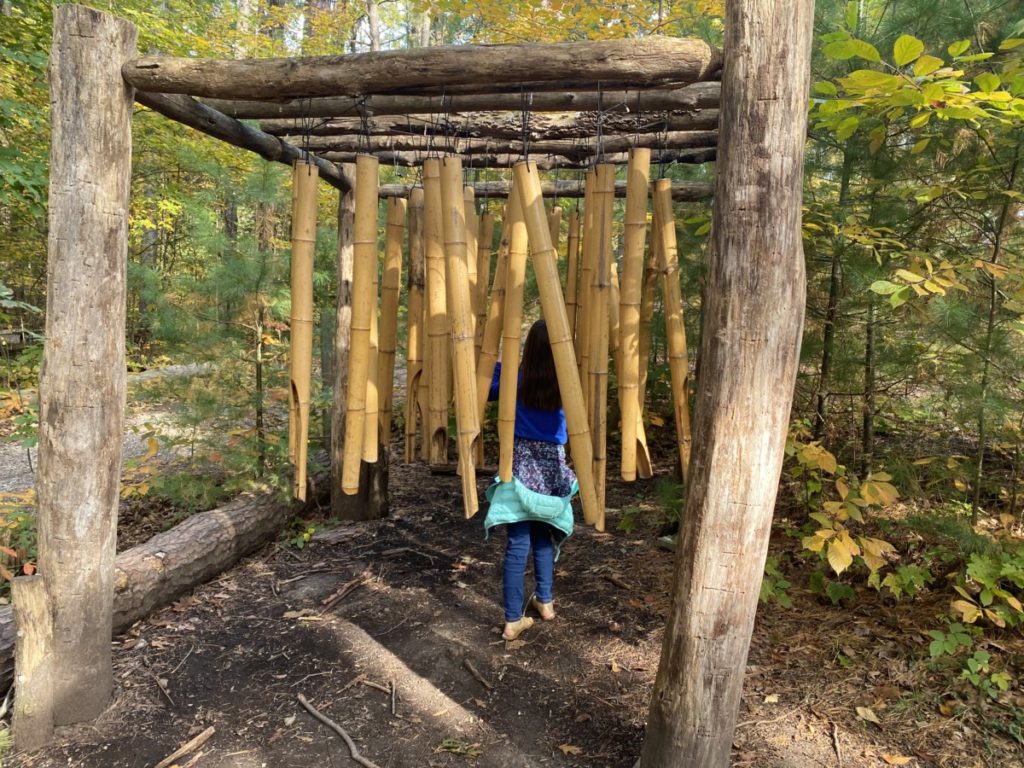 A youn girl walks through hanging Bamboo Musical Forest in the Holden Arboretum Adventureland area