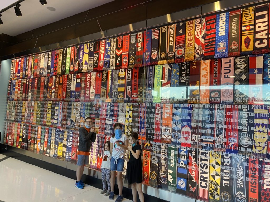 4 kids in front of the soccer scarf display at the National Soccer Hall of Fame