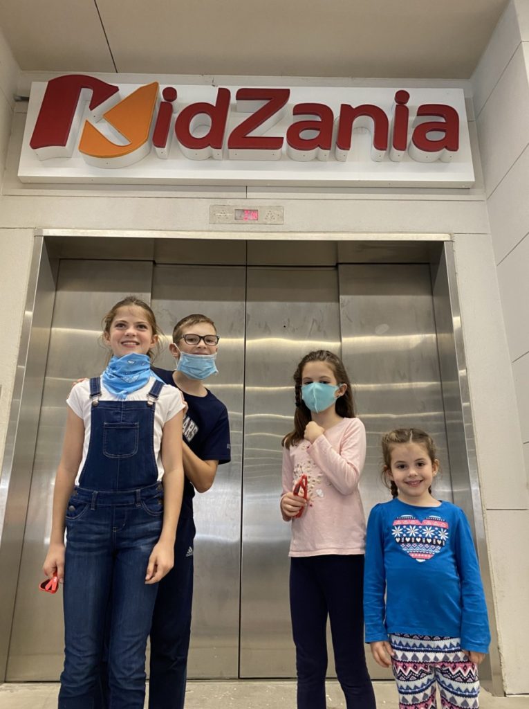 4 kids under the kidzania entrance in Frisco