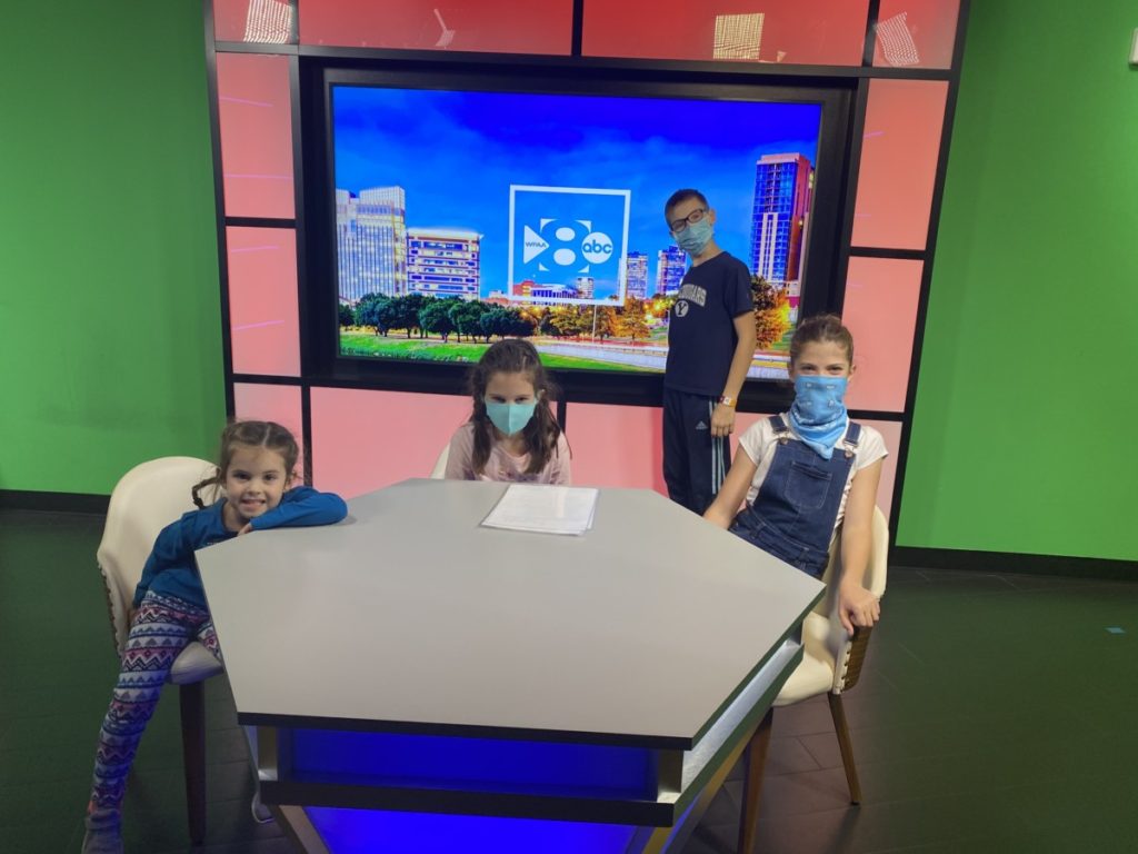 4 kids reporting the News at the Newscasting room in KidZania