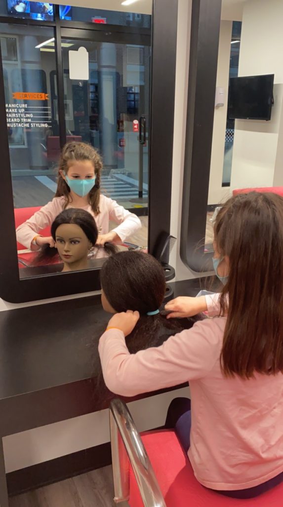 A girl styles a maniquin hair at the saloon at KidZania in Frisco Texas