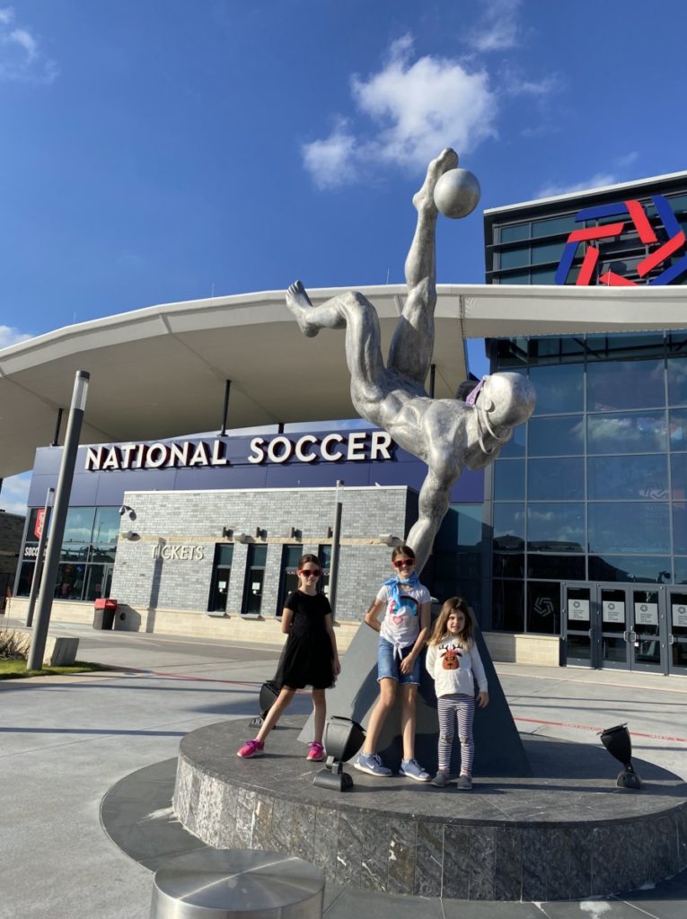 3 girls at the National Soccer Hall of Fame bicycle kicking statue