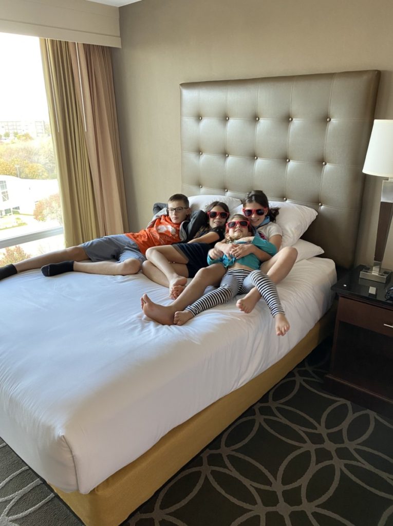 4 kids on the bed of the Drury Inn and Suites in Frisco