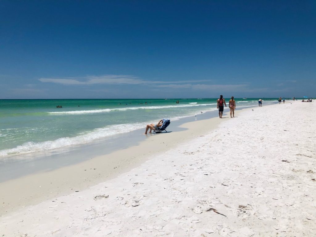 Beach goers walk and relax on Siesta Key Beach in Florida