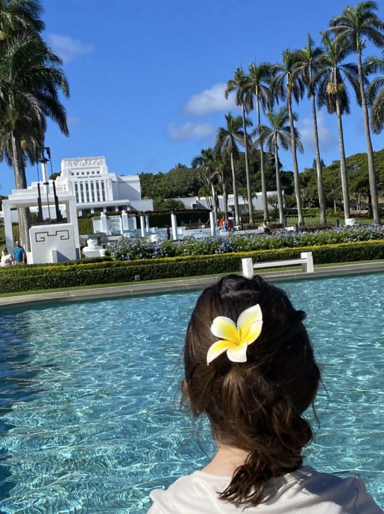 A young girls with a plumeria in her hair at the Lai'e LDS temple in Hawaii.