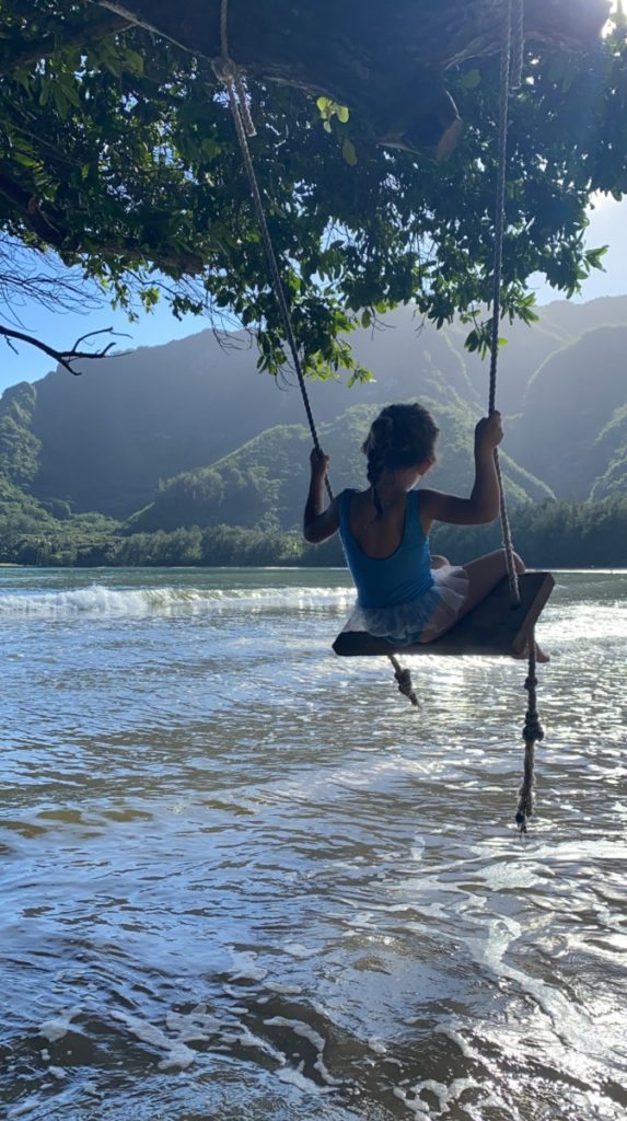 A young girl swinging at Kahana Bay Beach Park swing