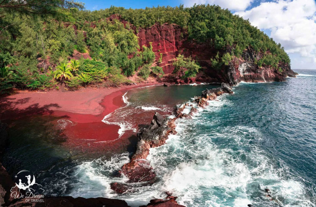the red sand, rocky coast and green cliffs at Red Sand Beach on Maui Hawaii 