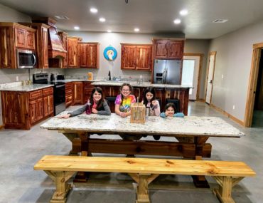 4 girls on the large dining table with the stocked kitchen at Lake Texoma Luxury Rentals