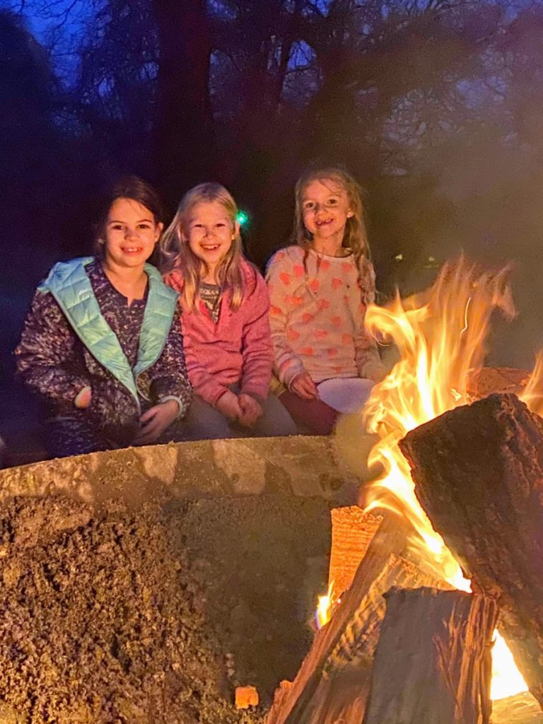 3 Girls sit around a giant Firepit at Lake Texoma VRBO