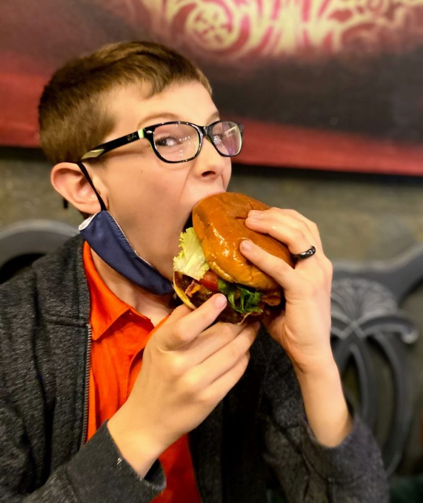 Boy eating Bacon Burger at Mulbery Cafe, Midland, TX