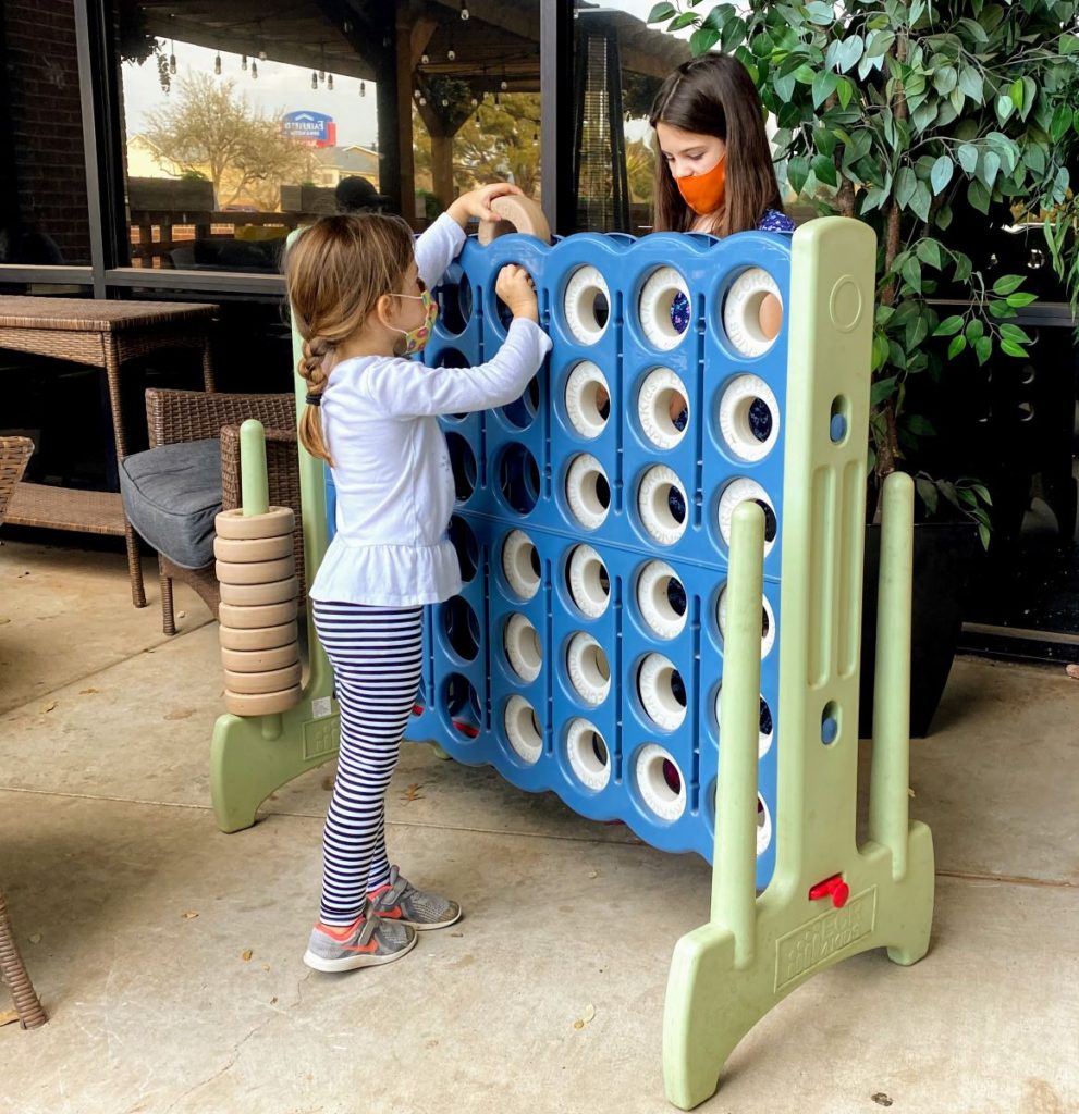 2 girls play Giant connect four game at Brew St Bakery