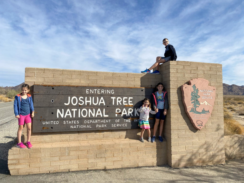 Joshua tree national Park sign with four kids