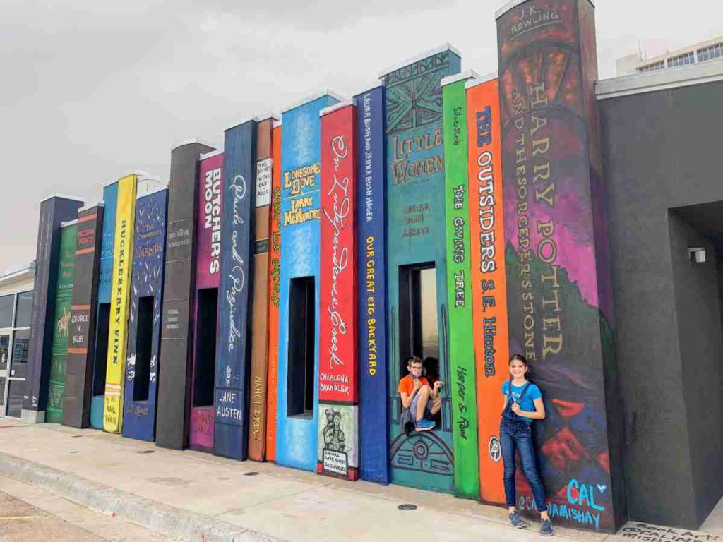 two kids show their favorite books at Midland Library book Mural
