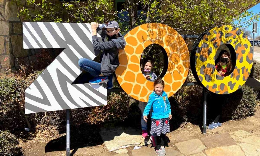 four kids at Abilene zoo sign